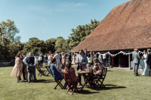 A wedding at a Sussex barn - guests enjoy drinks at Michelham Priory